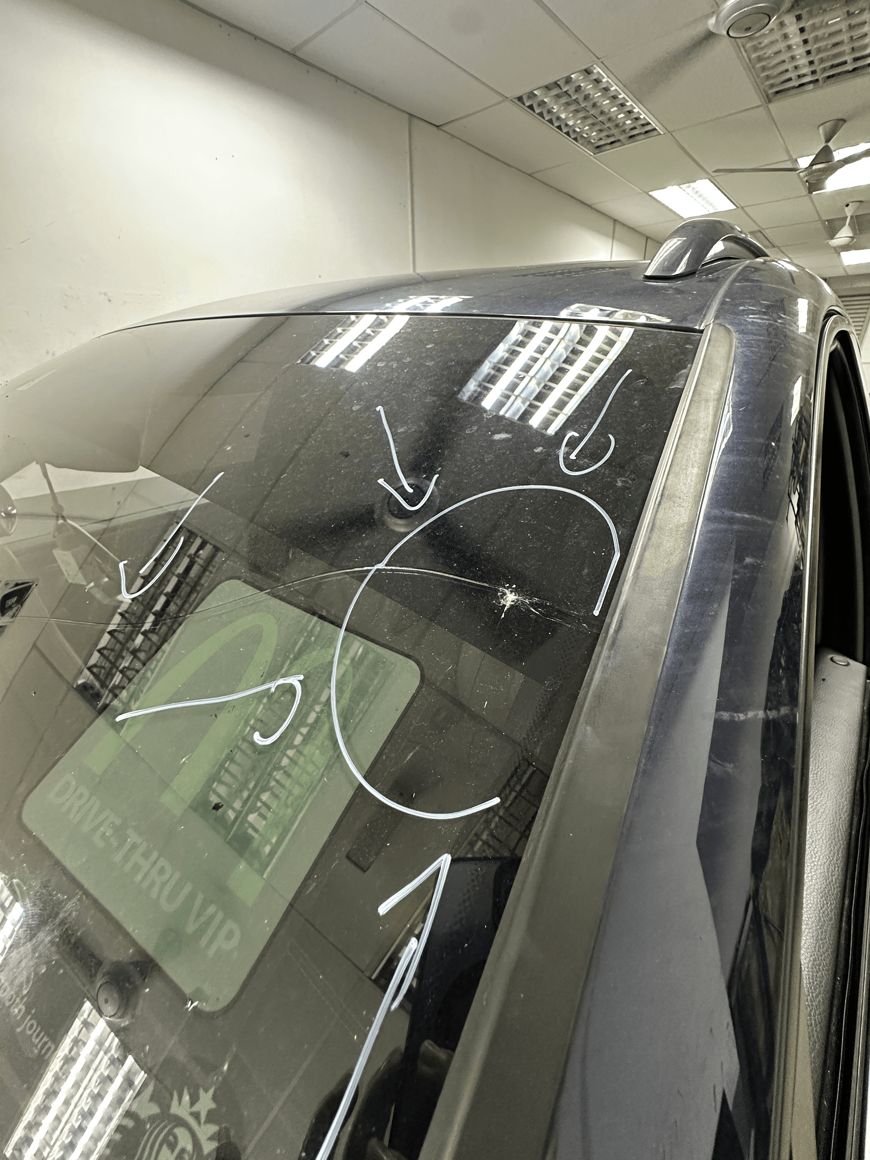 Sebelum penggantian: retakan windscreen Porsche dengan tanda bulatan dan anak panah putih asal